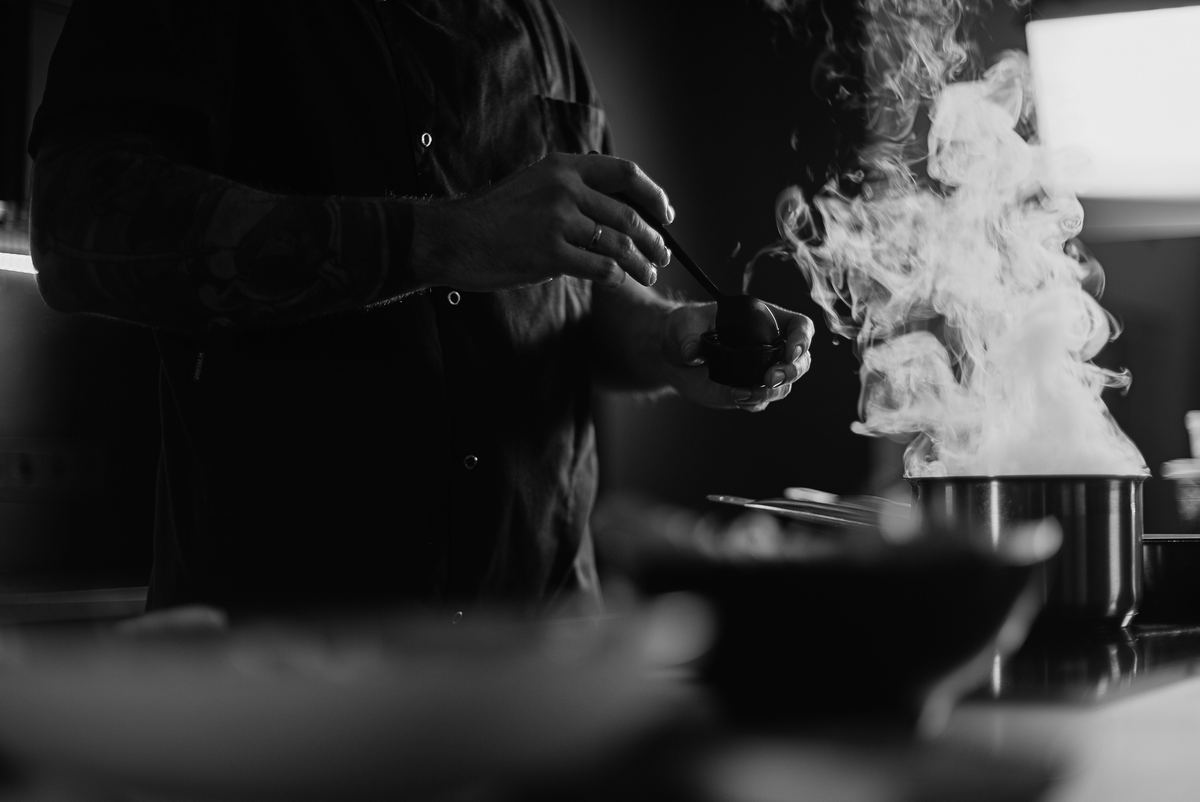 Chef cooking over a steaming pan